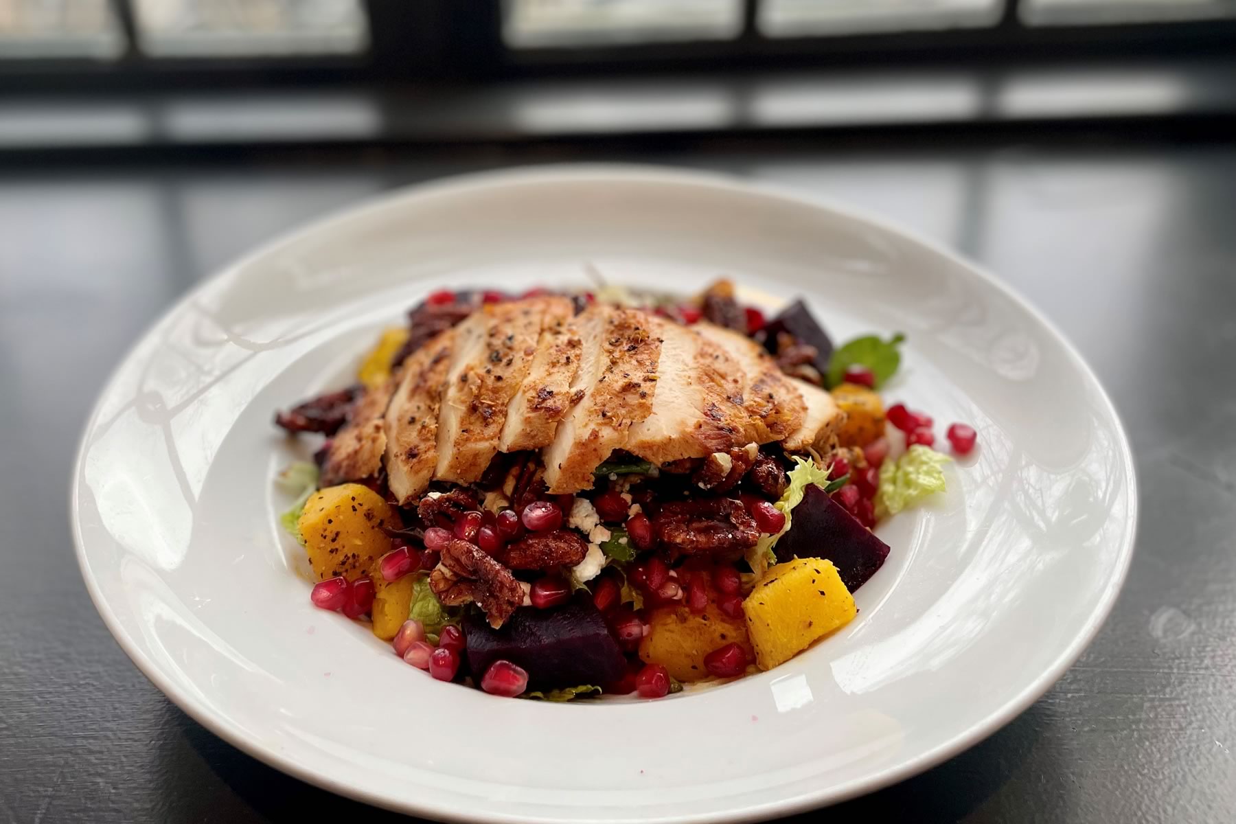 Winter Salad with mixed greens, grilled chicken, roasted squash, beets, pomegranate seeds, spiced candied pecans, crumbled goat’s cheese and a balsamic vinaigrette
